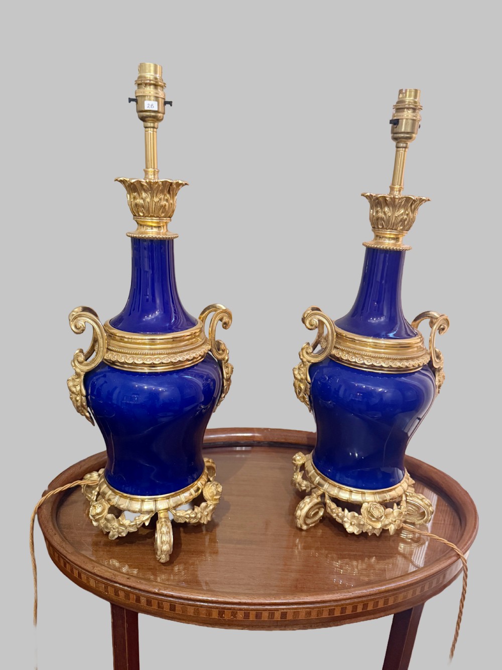 A pair of 19th-century French cobalt blue porcelain table lamps with gilt bronze ormolu mounts and scrolled handles. View VI