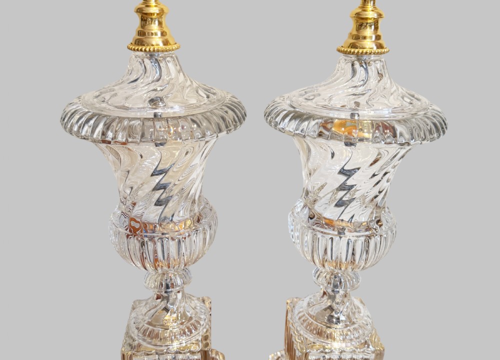A pair of 19th-century French clear cut-crystal urn-form table lamps featuring spiral fluting, square pedestals, and gilt-metal claw feet. View II