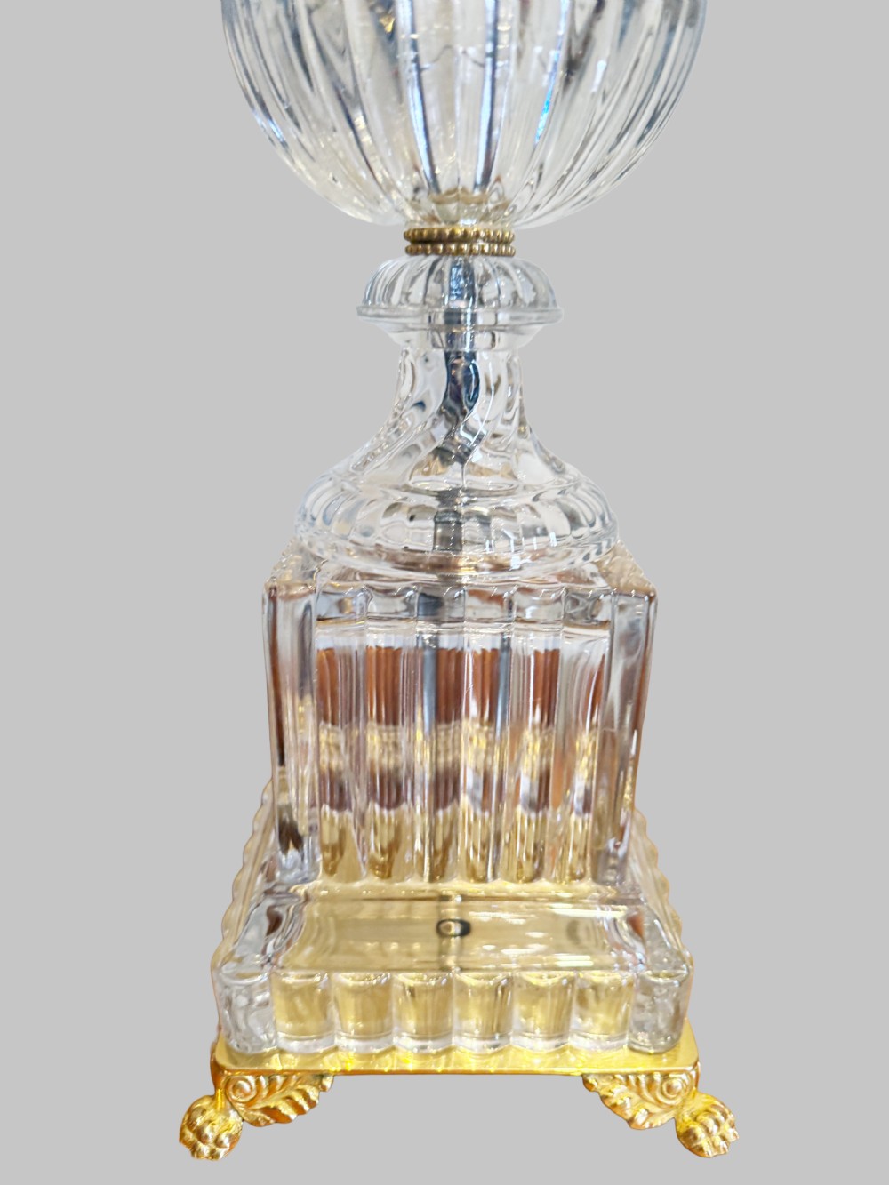 A pair of 19th-century French clear cut-crystal urn-form table lamps featuring spiral fluting, square pedestals, and gilt-metal claw feet. View V