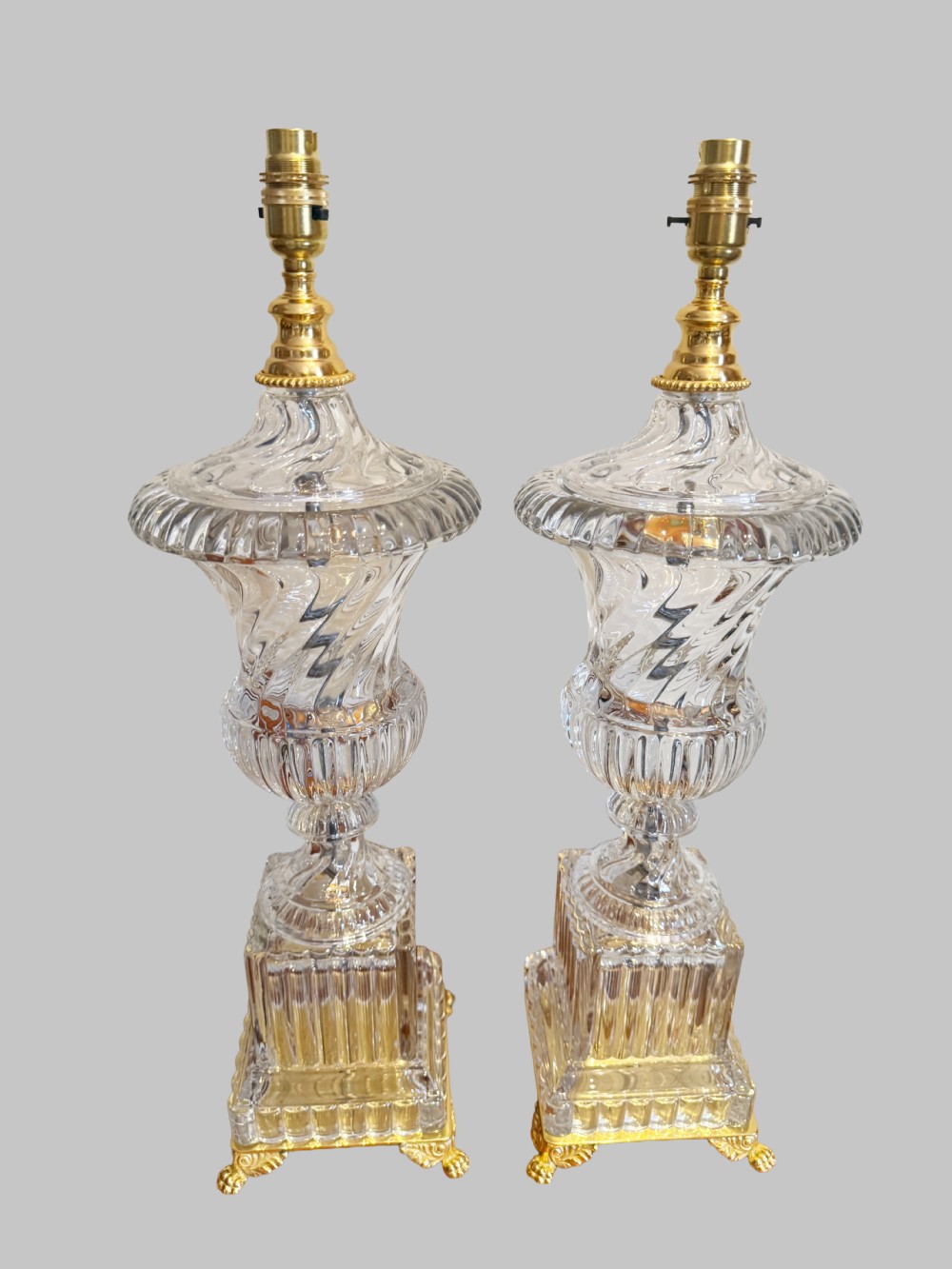 A pair of 19th-century French clear cut-crystal urn-form table lamps featuring spiral fluting, square pedestals, and gilt-metal claw feet. View VIII