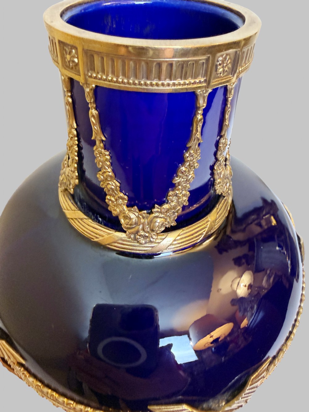 A pair of cobalt blue glass vases featuring ornate gilt bronze floral garlands, ribbon details, and metal rim mounts. View III