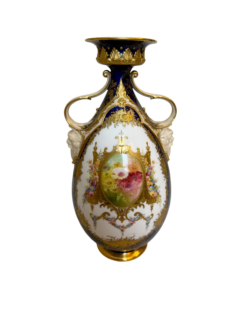 An antique Royal Doulton porcelain vase featuring cobalt blue and white glazes, heavy gilt scrolling, scroll handles with mask terminals, and a central hand-painted floral panel.