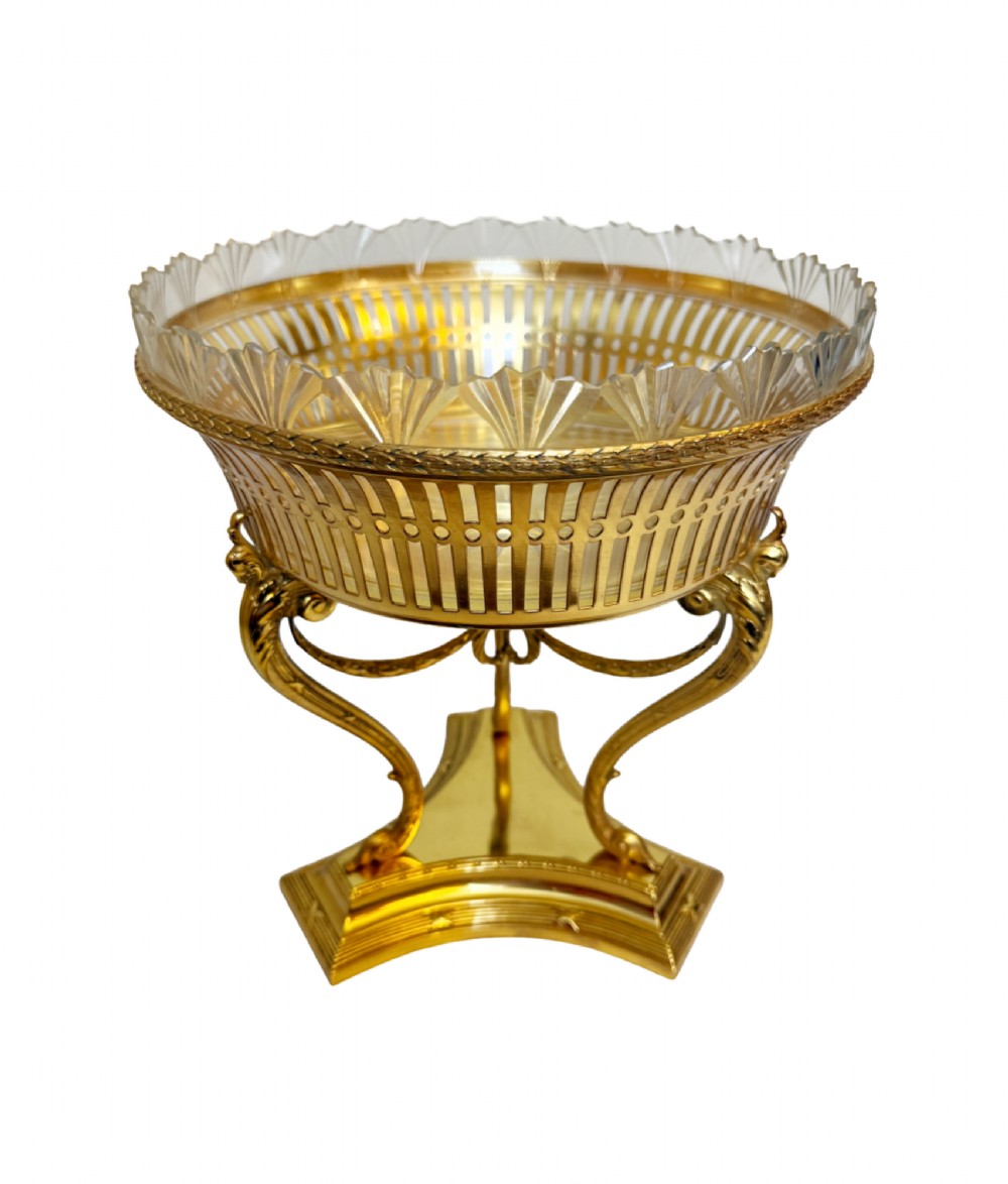 An antique French gilt bronze centrepiece with a pierced metal rim, tri-form base, and scalloped cut glass insert.