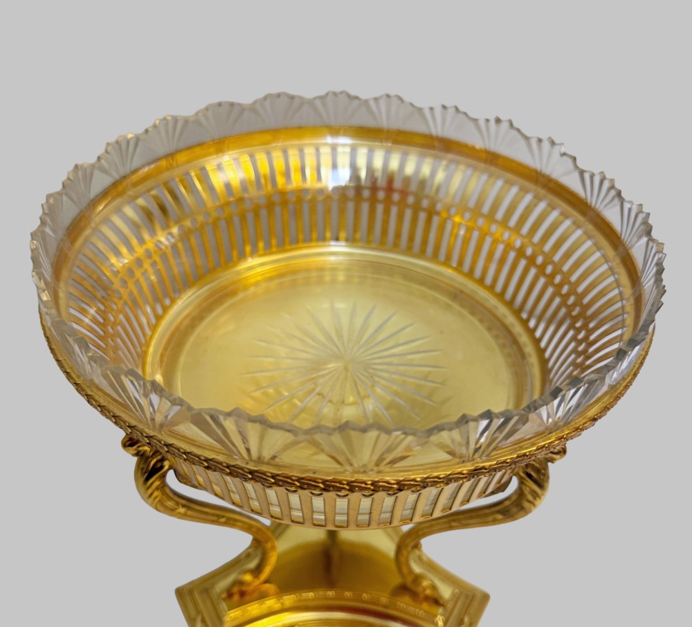 An antique French gilt bronze centrepiece with a pierced metal rim, tri-form base, and scalloped cut glass insert. View V