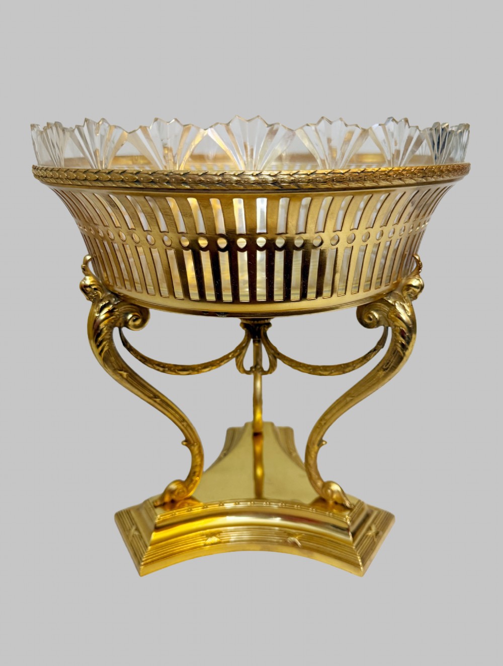 An antique French gilt bronze centrepiece with a pierced metal rim, tri-form base, and scalloped cut glass insert. View VI
