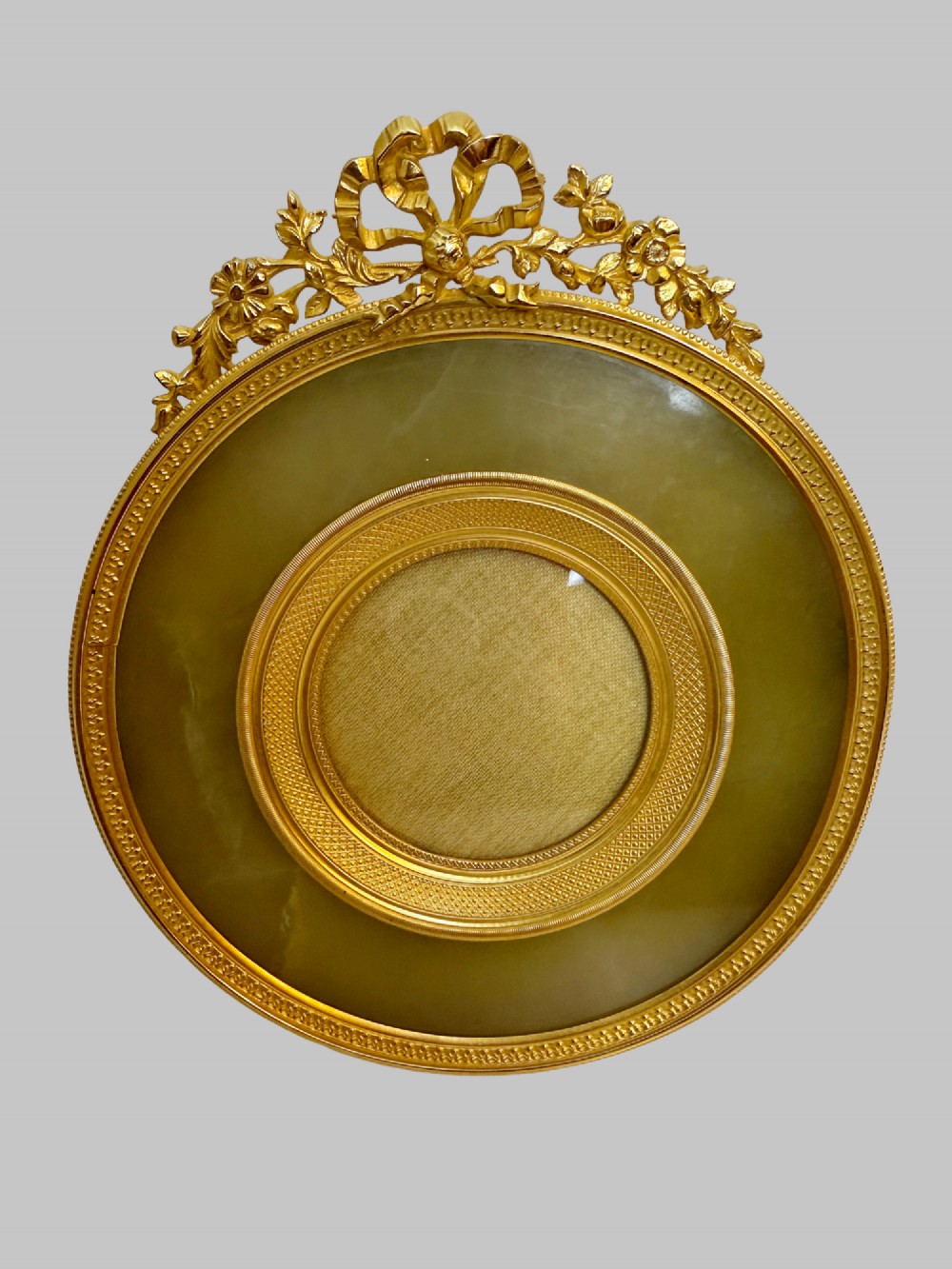 A trio of antique French gilt bronze picture frames featuring ribbon crests, beaded borders, and an onyx panel mount. View IV