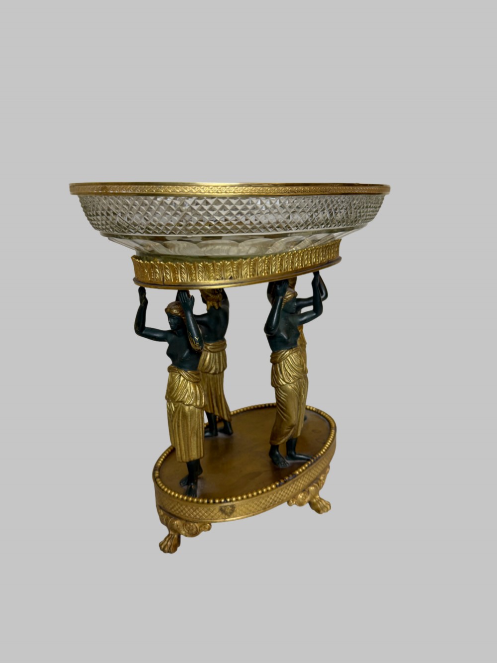 An early 19th-century cut-crystal bowl supported by four patinated bronze female caryatids with gilt drapery, set upon a circular gilt bronze base. View II