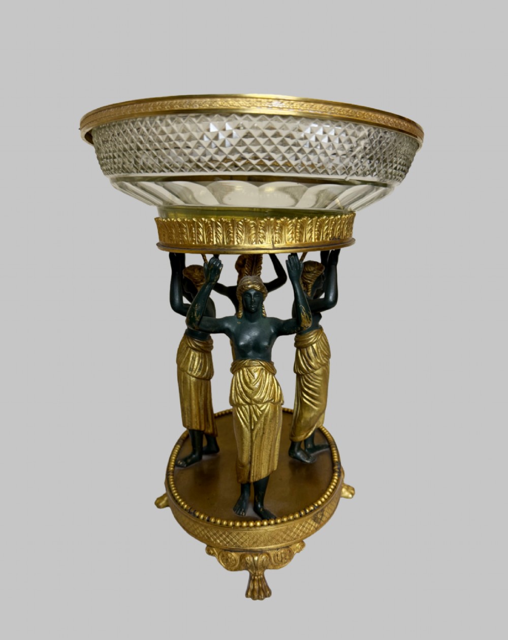 An early 19th-century cut-crystal bowl supported by four patinated bronze female caryatids with gilt drapery, set upon a circular gilt bronze base. View III
