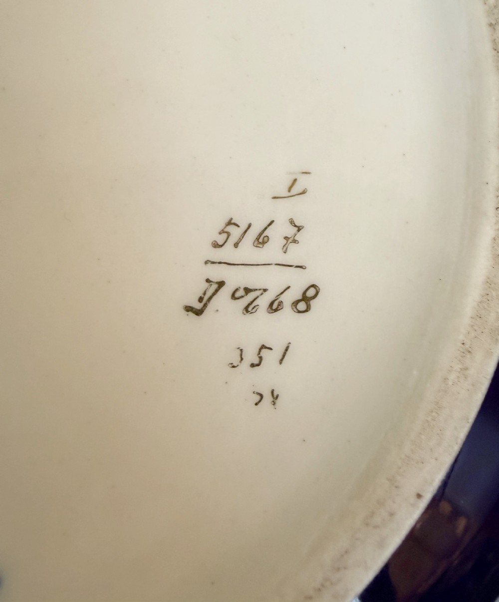 A circular antique French porcelain box featuring a central hand-painted classical scene of three women framed by cobalt blue, gilt embellishments, and white enamel dots. View VII