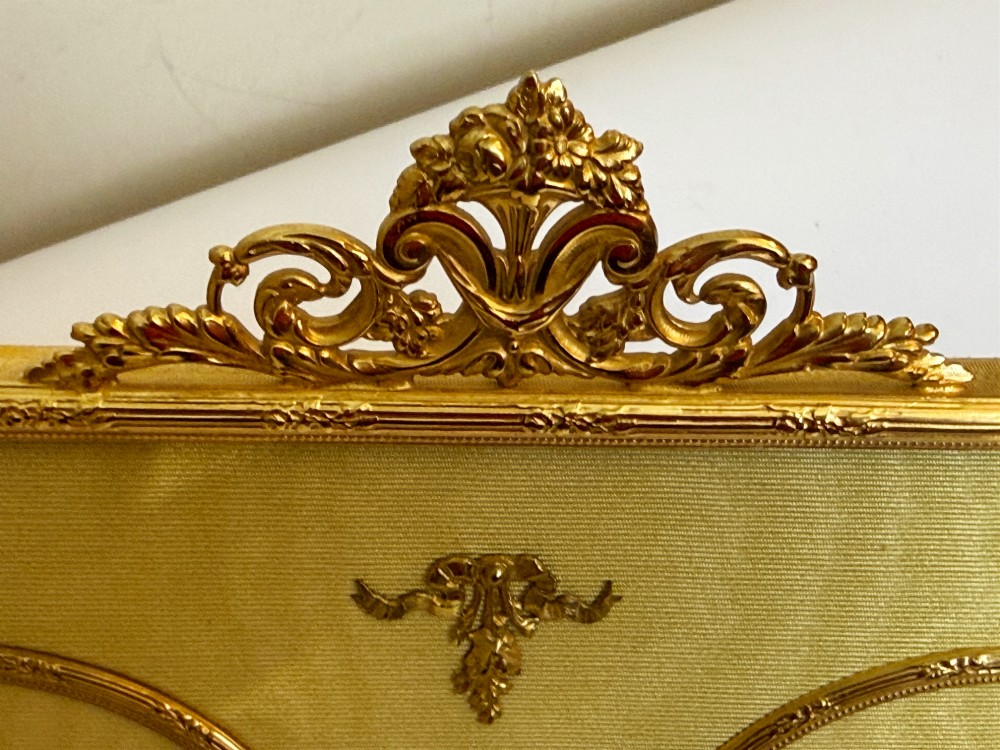 A 19th-century rectangular French gilt bronze frame featuring two circular photograph openings set against a cream silk background, adorned with a floral crest and ribbon mounts. View IV