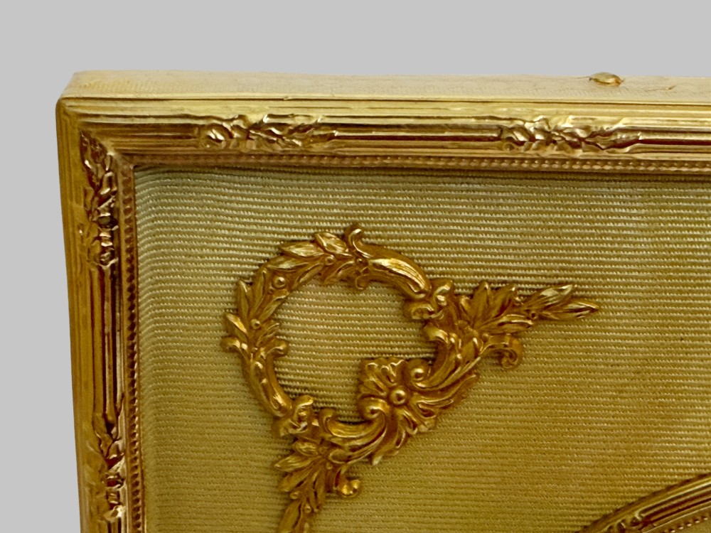 A 19th-century rectangular French gilt bronze frame featuring two circular photograph openings set against a cream silk background, adorned with a floral crest and ribbon mounts. View VI