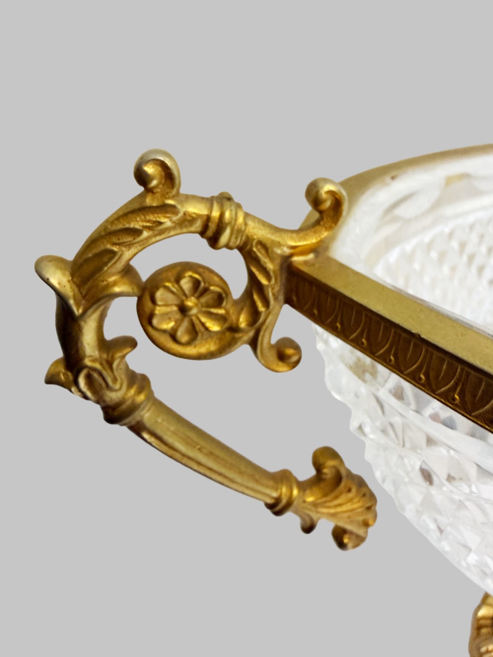A late 19th-century French boat-shaped cut crystal centrepiece bowl set within gilded bronze mounts with dual scroll handles and a footed square base. View IV