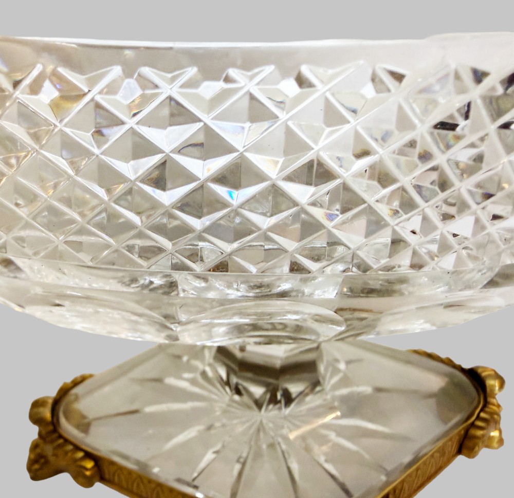 A late 19th-century French boat-shaped cut crystal centrepiece bowl set within gilded bronze mounts with dual scroll handles and a footed square base. View VI