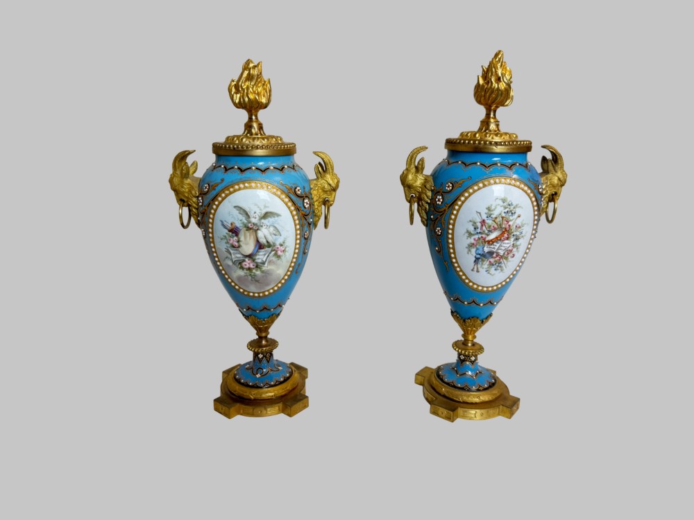 A pair of turquoise blue enamelled cassolette urns featuring gilt-bronze ram head handles, flame finials, and painted romantic pastoral vignettes. View IV