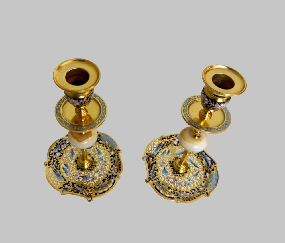 A pair of 19th-century gilt bronze candlesticks featuring floral champleve enamel decoration, central onyx knops, and shaped wide bases. View III