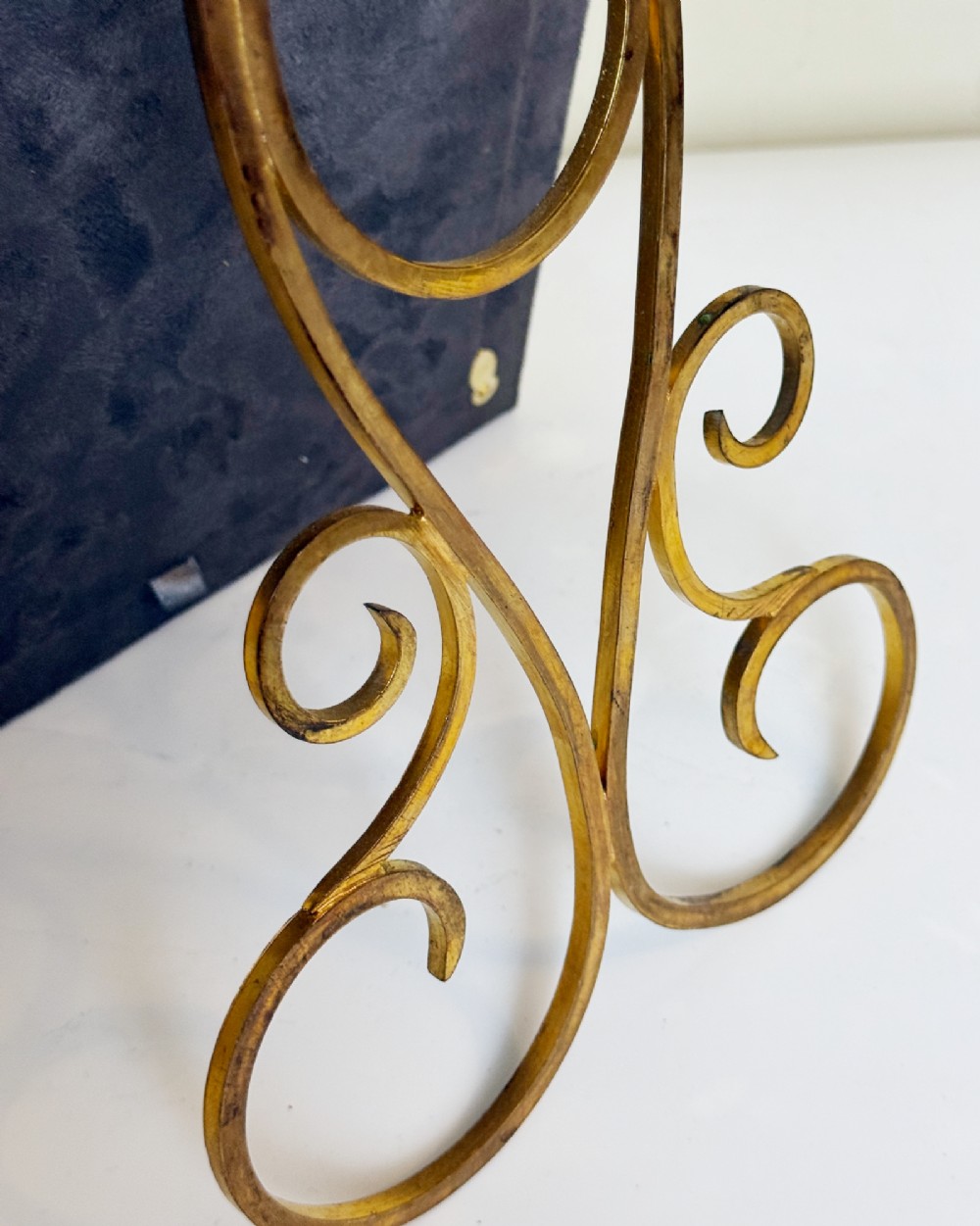 A rectangular gilt bronze picture frame featuring a blue velvet border, ornate corner mounts, and an elaborate floral crest at the top. View IV