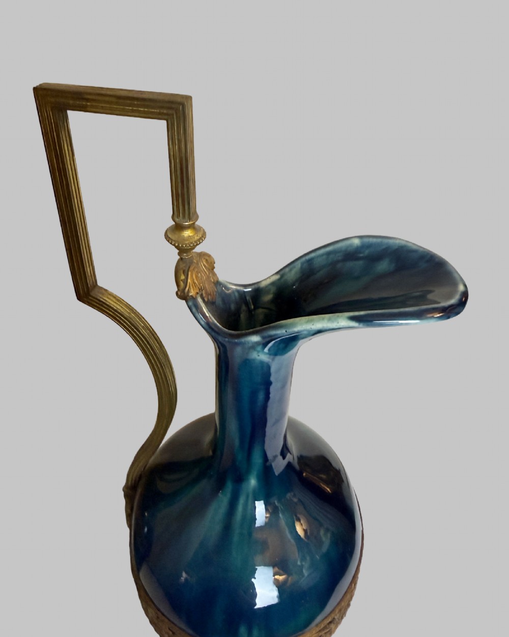 A pair of slender blue porcelain ewers featuring decorative gilt bronze mounts, angular handles, and flared spouts. View III