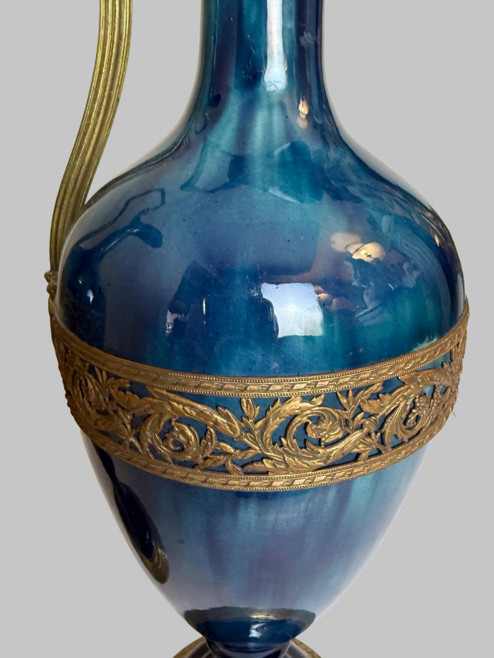 A pair of slender blue porcelain ewers featuring decorative gilt bronze mounts, angular handles, and flared spouts. View IV
