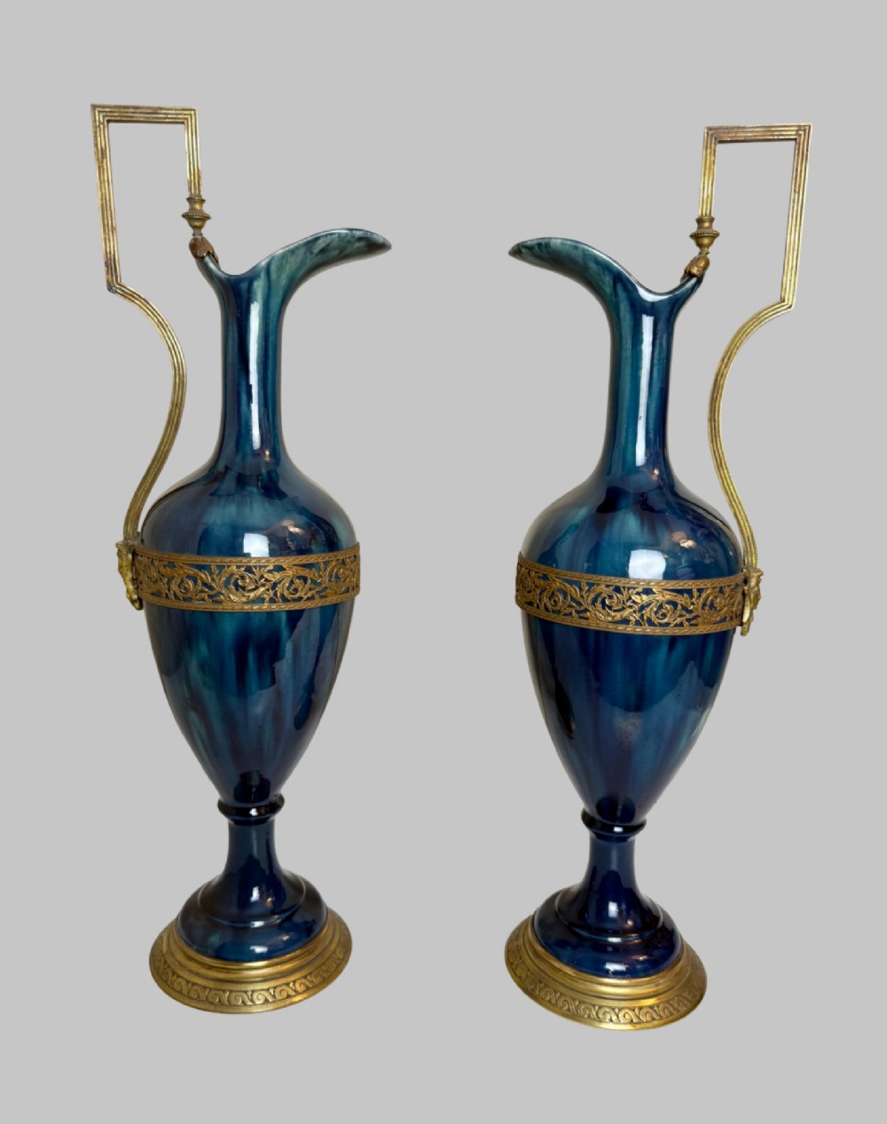 A pair of slender blue porcelain ewers featuring decorative gilt bronze mounts, angular handles, and flared spouts. View VI