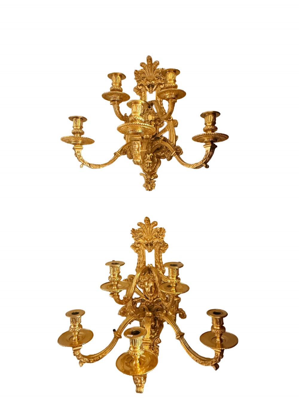 A pair of late nineteenth-century French gilt bronze five-light wall sconces featuring ornate rococo scrollwork and mascaron motifs.