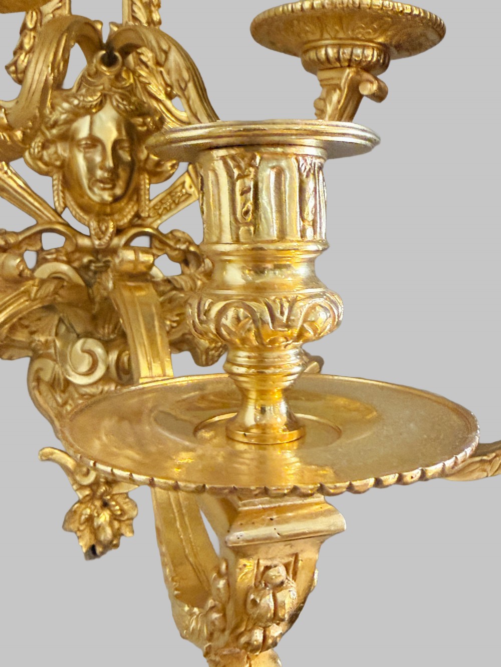 A pair of late nineteenth-century French gilt bronze five-light wall sconces featuring ornate rococo scrollwork and mascaron motifs. View III
