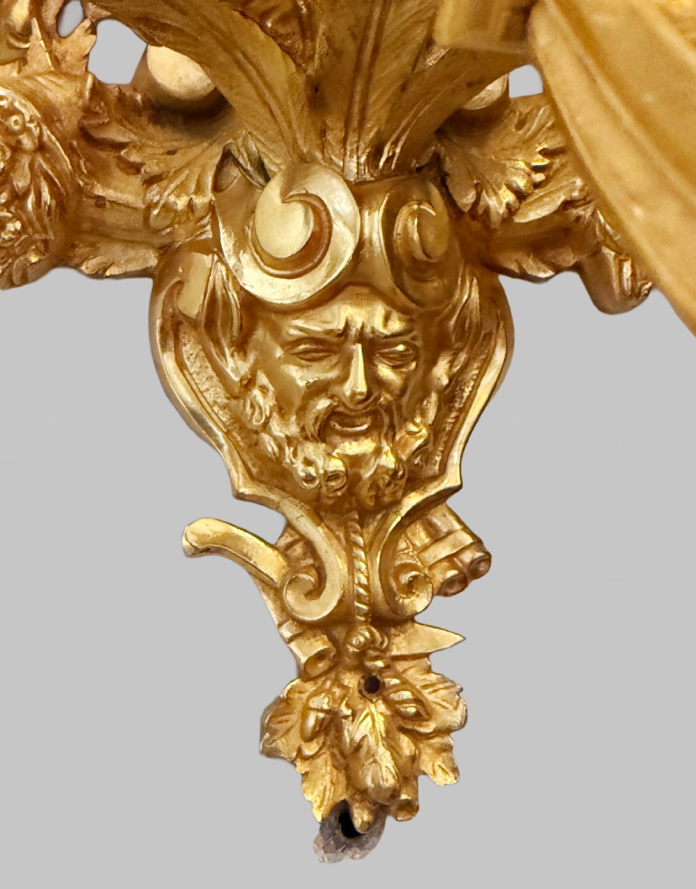 A pair of late nineteenth-century French gilt bronze five-light wall sconces featuring ornate rococo scrollwork and mascaron motifs. View IV