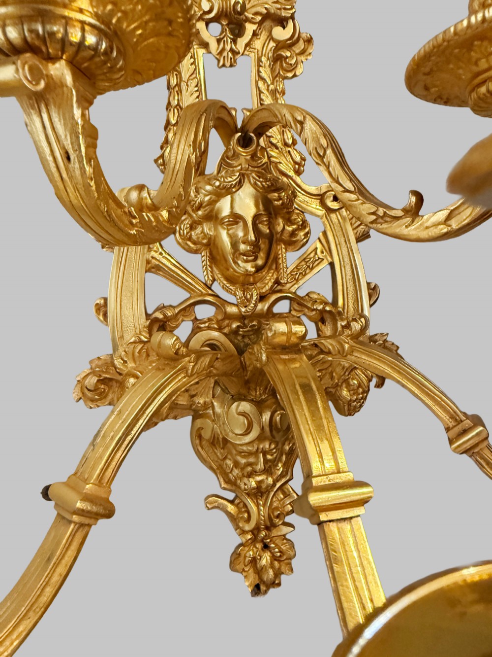 A pair of late nineteenth-century French gilt bronze five-light wall sconces featuring ornate rococo scrollwork and mascaron motifs. View VII
