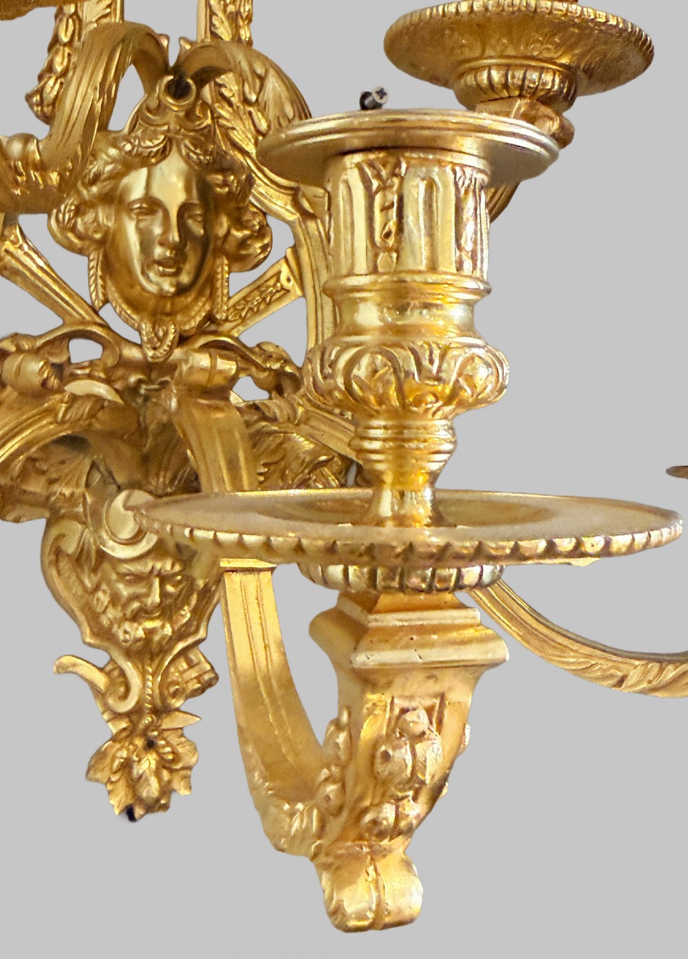 A pair of late nineteenth-century French gilt bronze five-light wall sconces featuring ornate rococo scrollwork and mascaron motifs. View VIII