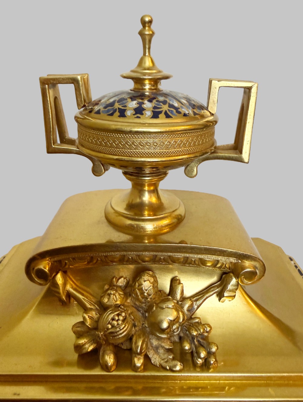 A late 19th-century French clock garniture featuring a gilt bronze mantel clock flanked by two matching champleve enamel side urns. View IV