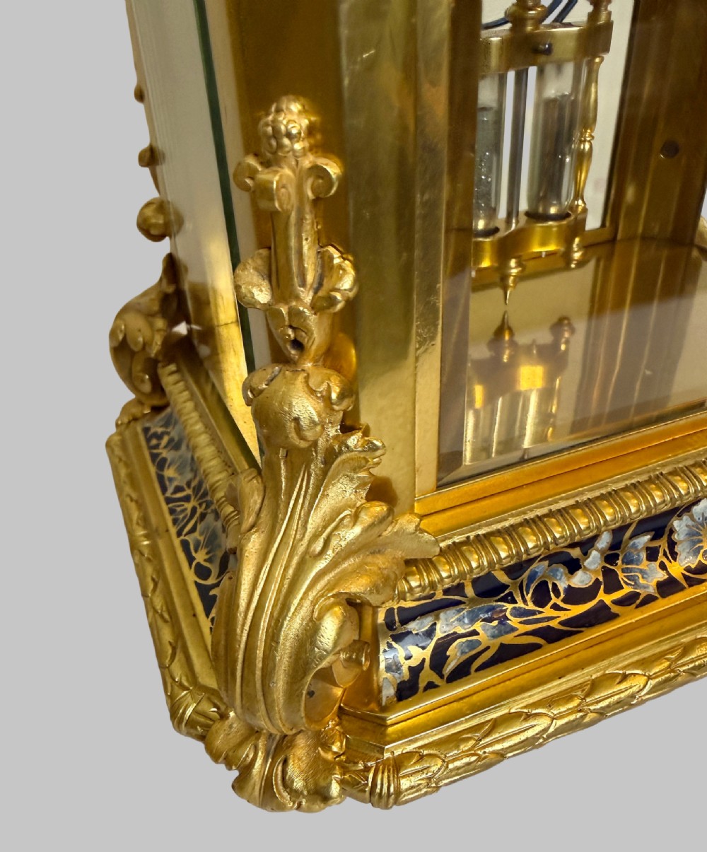 A late 19th-century French clock garniture featuring a gilt bronze mantel clock flanked by two matching champleve enamel side urns. View VI