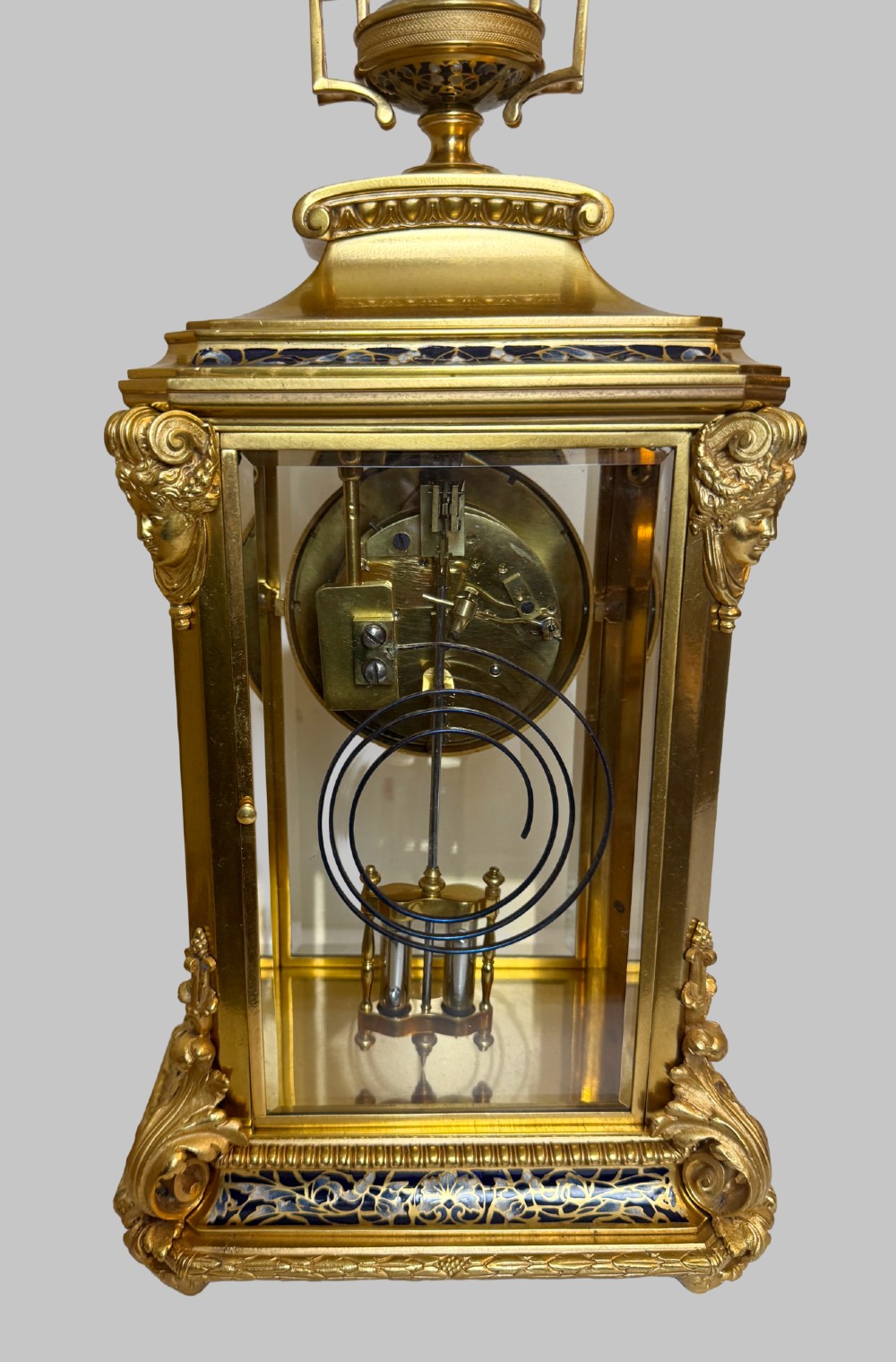 A late 19th-century French clock garniture featuring a gilt bronze mantel clock flanked by two matching champleve enamel side urns. View VIII