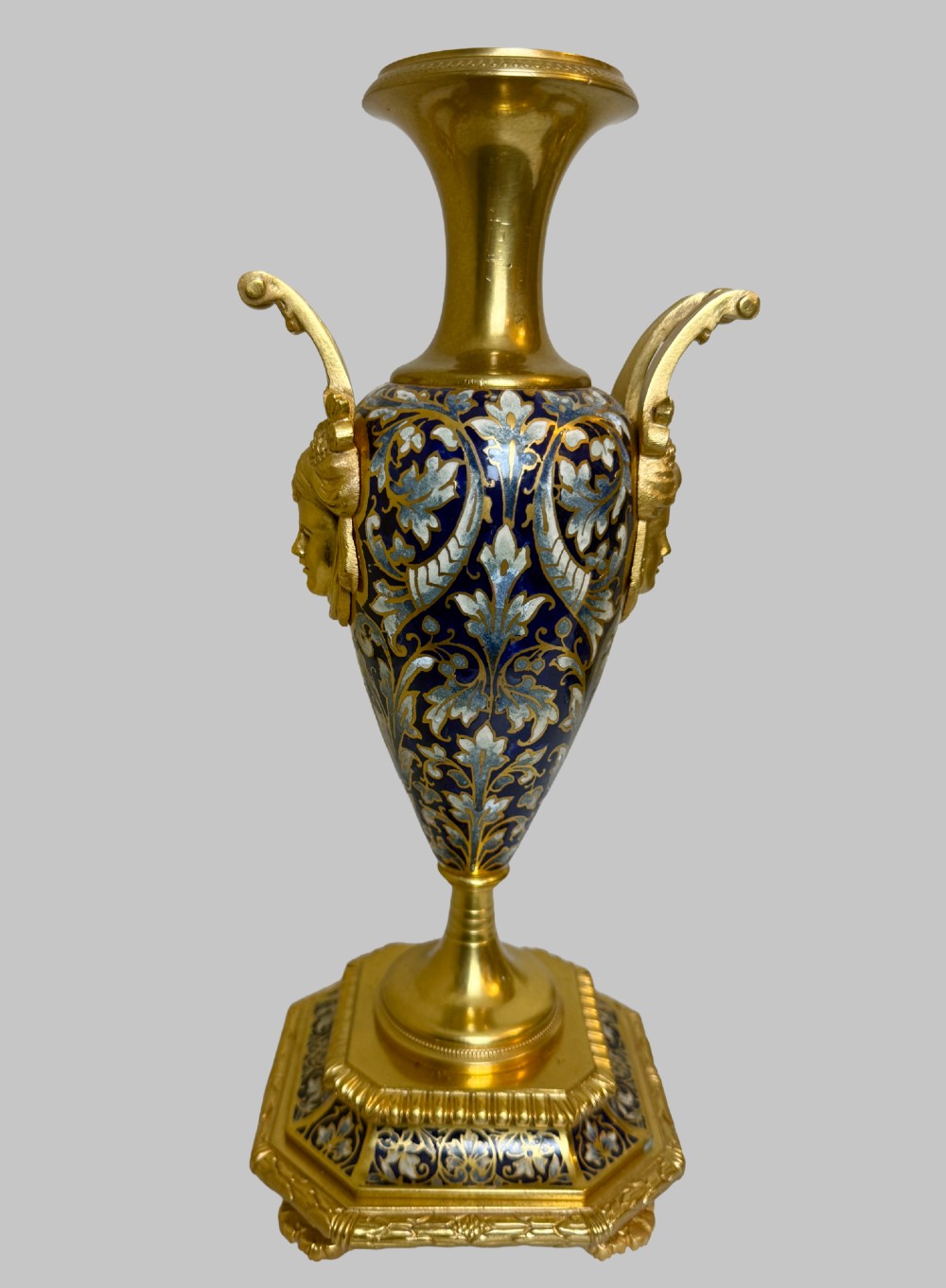 A late 19th-century French clock garniture featuring a gilt bronze mantel clock flanked by two matching champleve enamel side urns. View XI