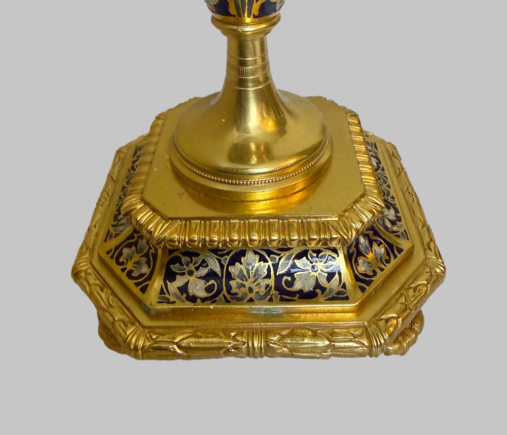 A late 19th-century French clock garniture featuring a gilt bronze mantel clock flanked by two matching champleve enamel side urns. View XIII