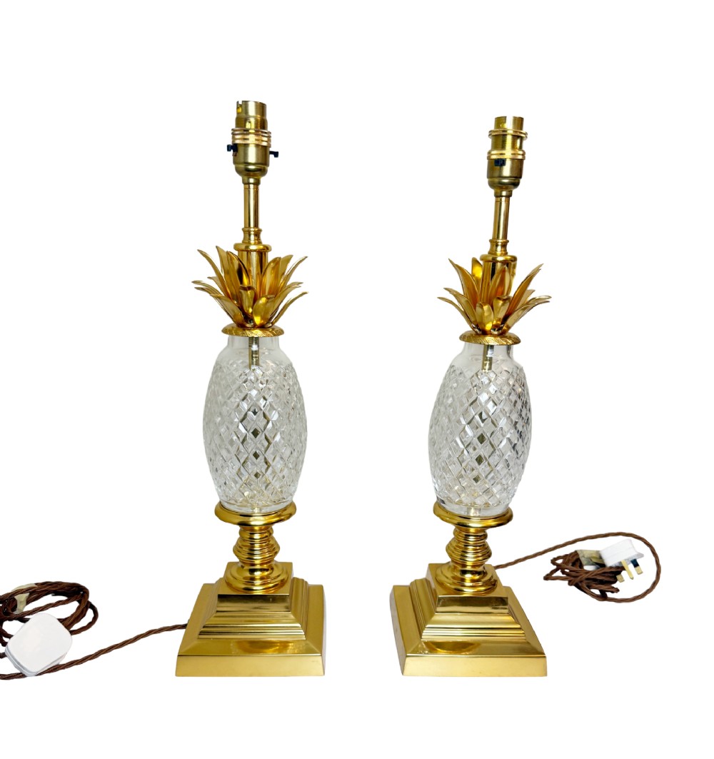 A pair of French gilt bronze and cut crystal table lamps designed in the shape of pineapples on square stepped bases.