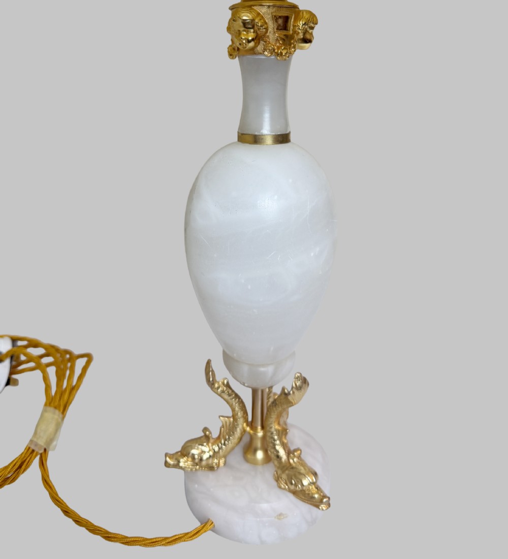 A pair of French onyx urn-shaped table lamps featuring gilt bronze dolphin feet and cream pleated shades. View III