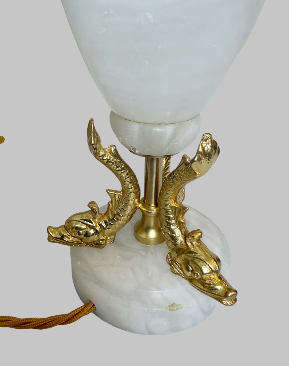 A pair of French onyx urn-shaped table lamps featuring gilt bronze dolphin feet and cream pleated shades. View IV