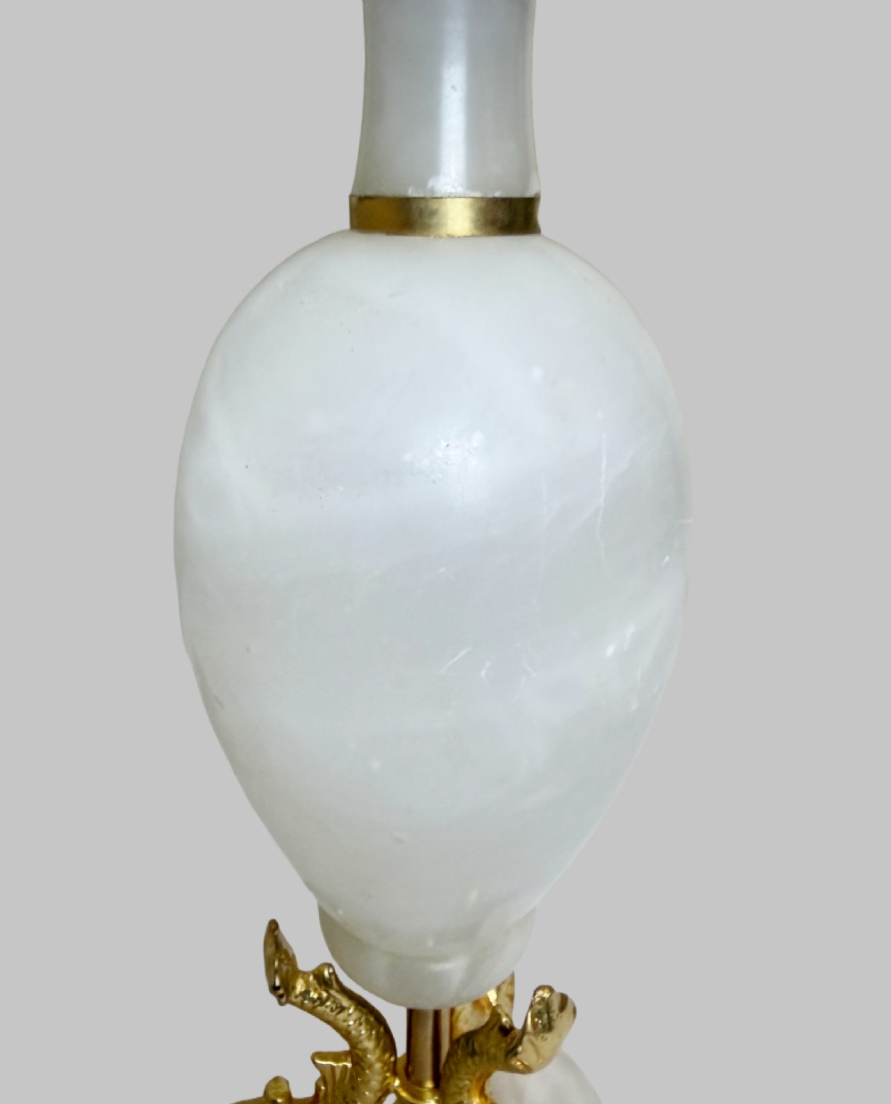 A pair of French onyx urn-shaped table lamps featuring gilt bronze dolphin feet and cream pleated shades. View V