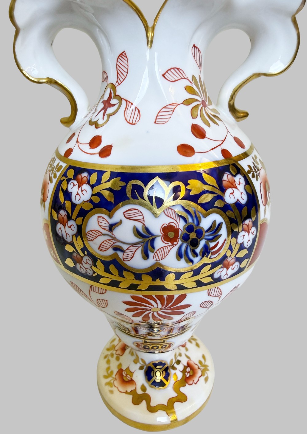 A pair of 19th-century Spode porcelain twin-handled vases decorated in a cobalt blue, iron red, and gold leaf Imari pattern. View VI