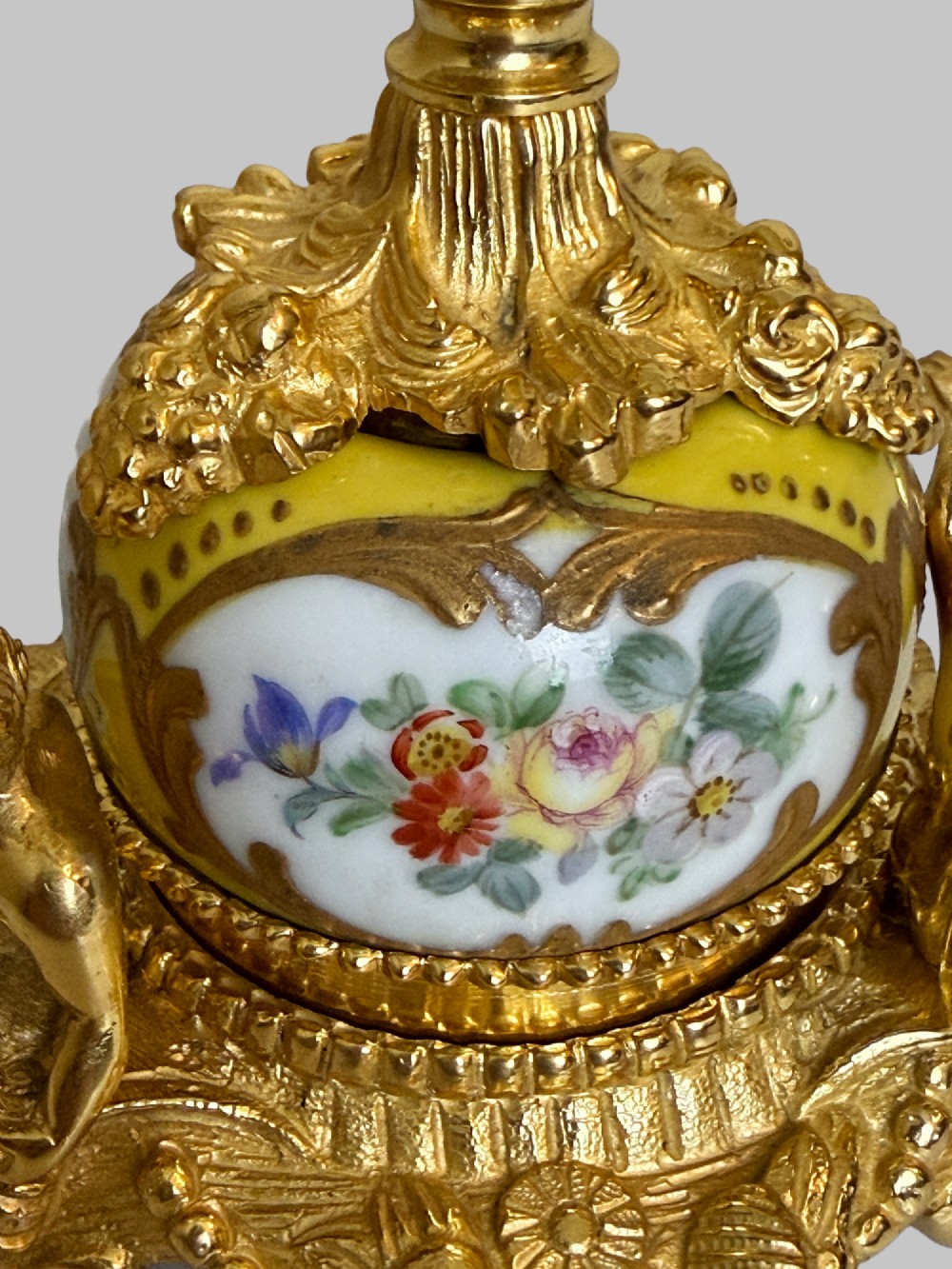 An ornate gilt bronze centrepiece dish featuring a cut crystal bowl, hand-painted porcelain cherub panels, and three seated bronze putti figures on a scrolled base. View V