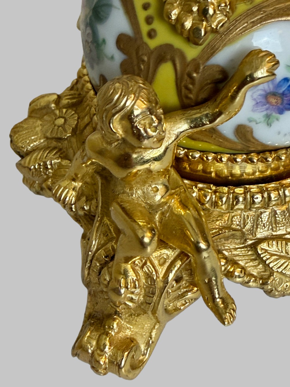 An ornate gilt bronze centrepiece dish featuring a cut crystal bowl, hand-painted porcelain cherub panels, and three seated bronze putti figures on a scrolled base. View IX