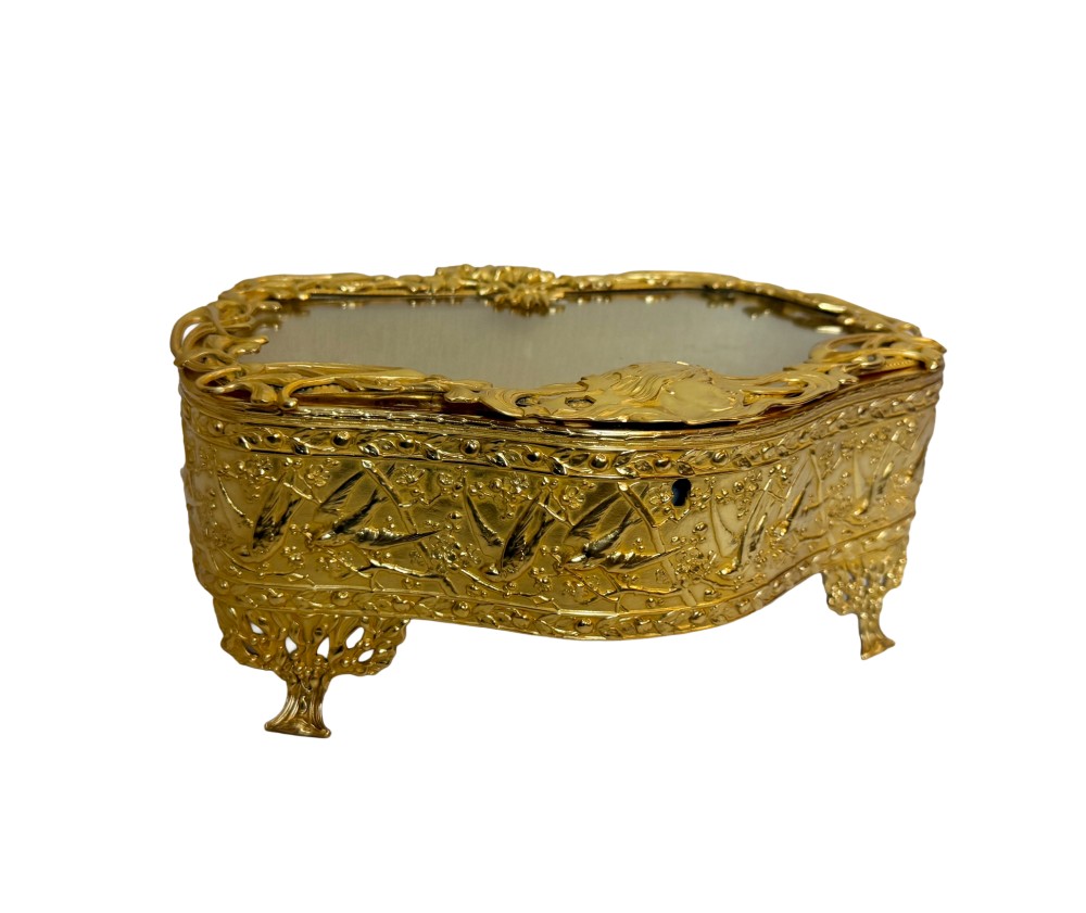 An Art Nouveau gilt bronze jewellery box featuring embossed bird motifs and a bevelled glass lid.
