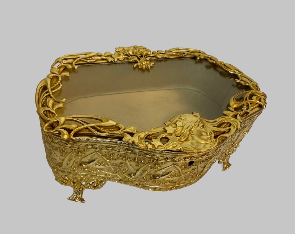 An Art Nouveau gilt bronze jewellery box featuring embossed bird motifs and a bevelled glass lid. View II