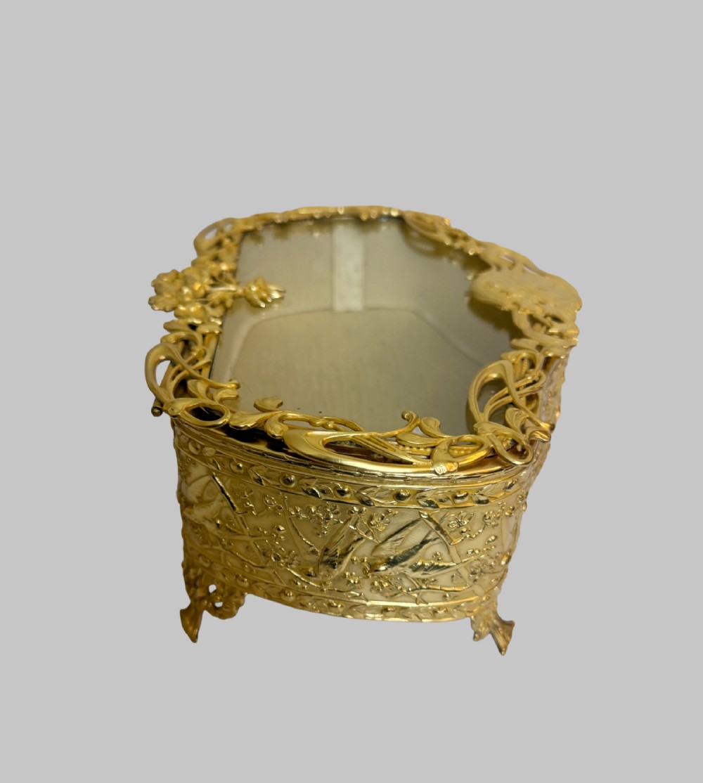 An Art Nouveau gilt bronze jewellery box featuring embossed bird motifs and a bevelled glass lid. View III