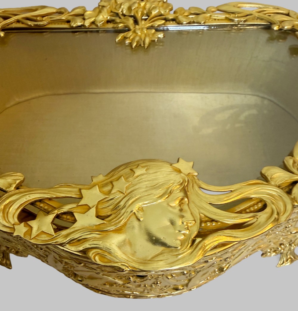 An Art Nouveau gilt bronze jewellery box featuring embossed bird motifs and a bevelled glass lid. View VI