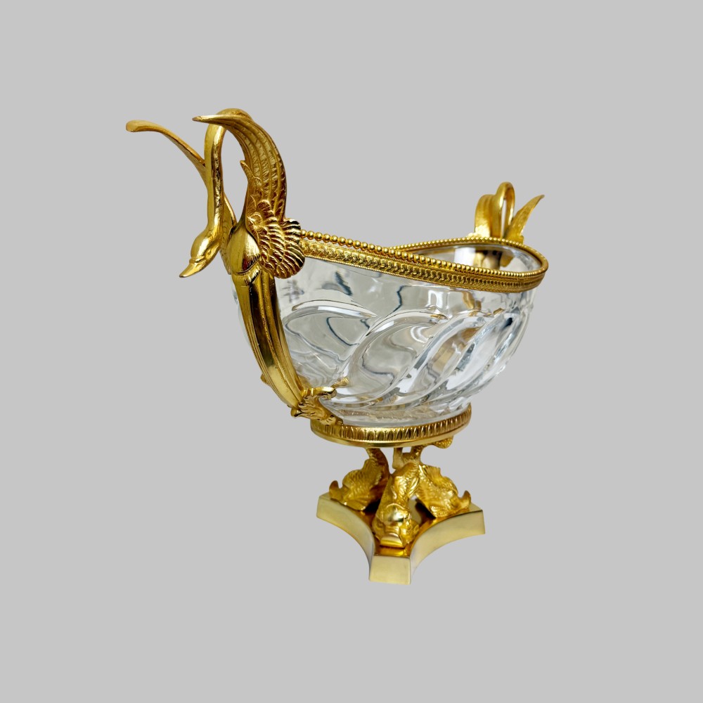 A 19th-century boat-shaped cut-crystal bowl with gilt-bronze swan-form handles and a pedestal base supported by gilt dolphins. View II