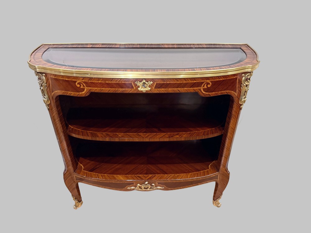A late 19th-century French Louis XV style demilune open bookcase featuring marquetry wood veneer, gilt-bronze ormolu mounts, open shelving, and a glass vitrine top. View IV