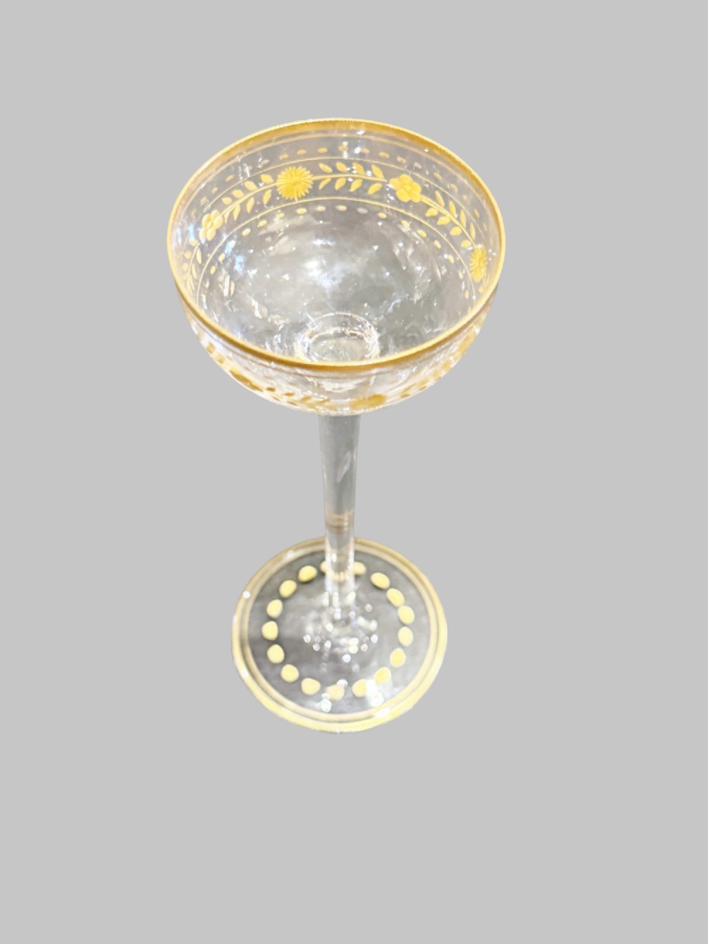 A set of twelve delicate clear glass liqueur stemware pieces with gilt decoration, resting in a padded silk-lined fitted black case. View II