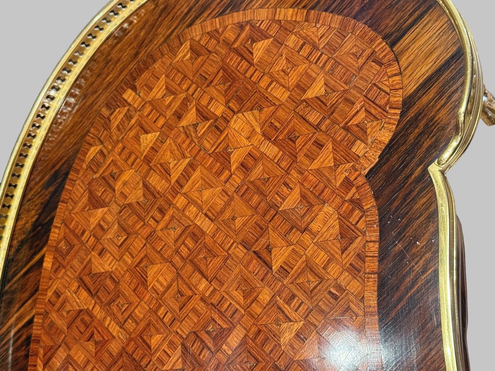 A nineteenth-century kidney-shaped side table with geometric parquetry inlay, a pierced brass gallery rim, and ormolu mounts on cabriole legs. View VIII