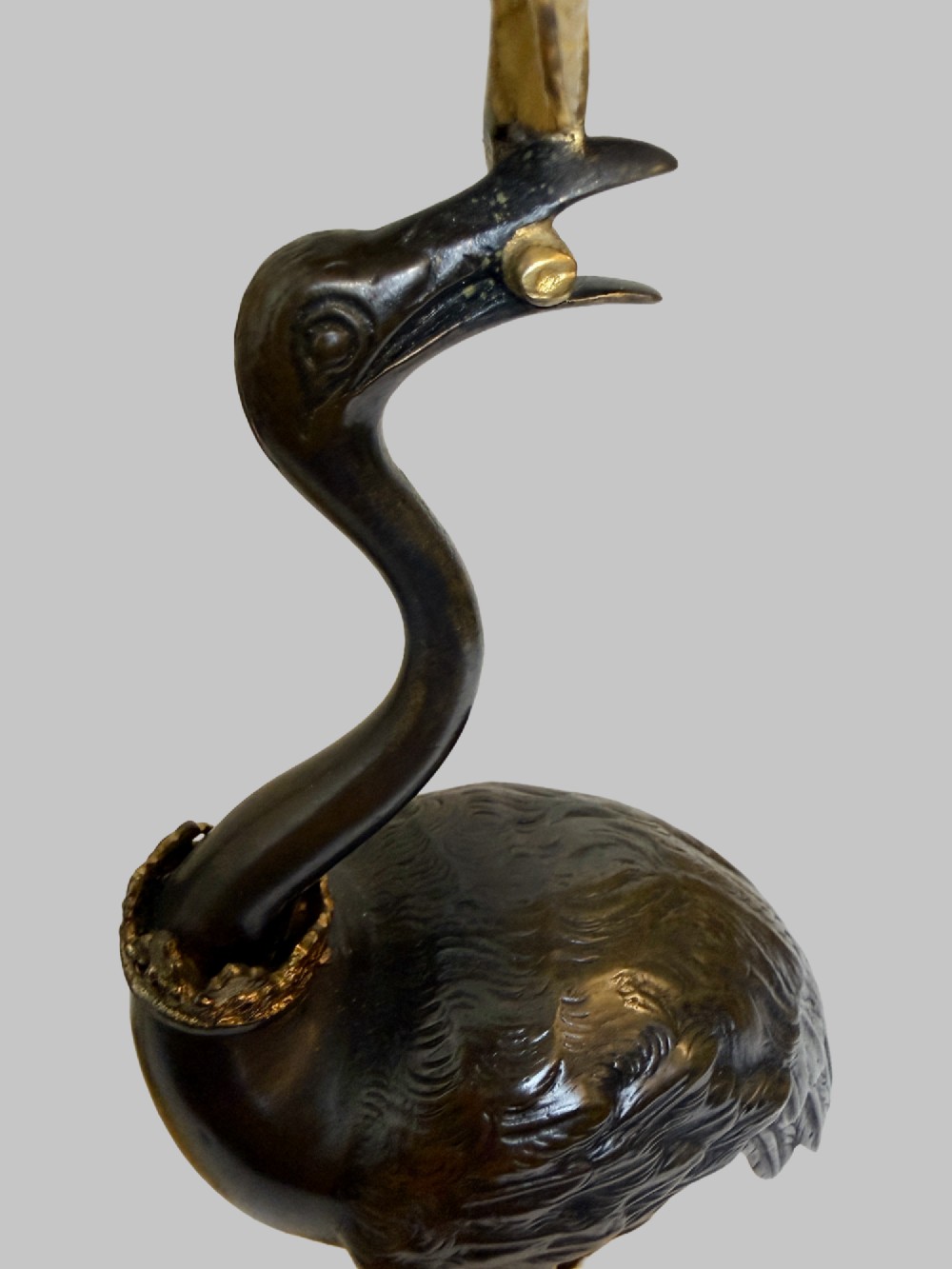 A pair of late nineteenth-century gilt and patinated bronze candlesticks featuring standing birds holding palm stems with floral candle nozzles atop rocky bases. View VII