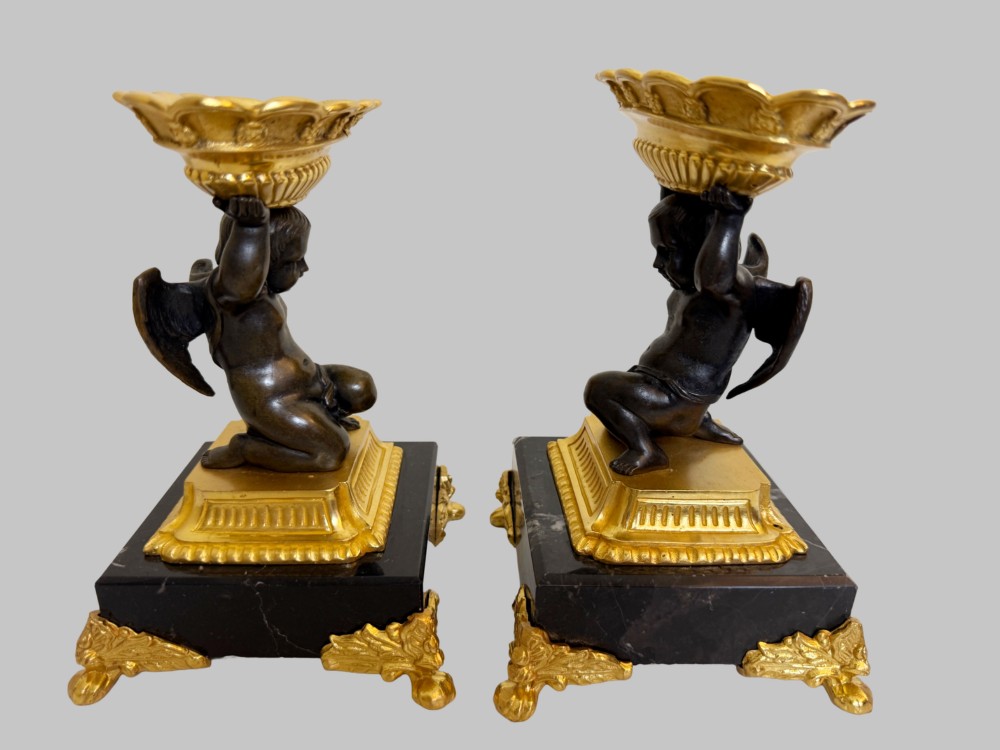 A pair of nineteenth-century gilt bronze and black marble tazzas featuring dark bronze winged cherub figures supporting fluted shallow bowls. View VI